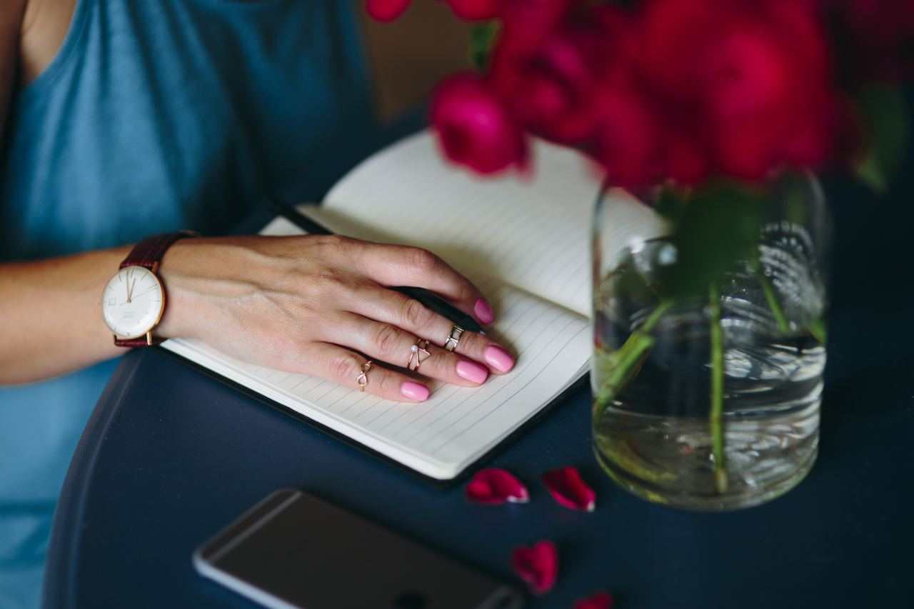 kaboompics.com_Female hand with rings on a notebook